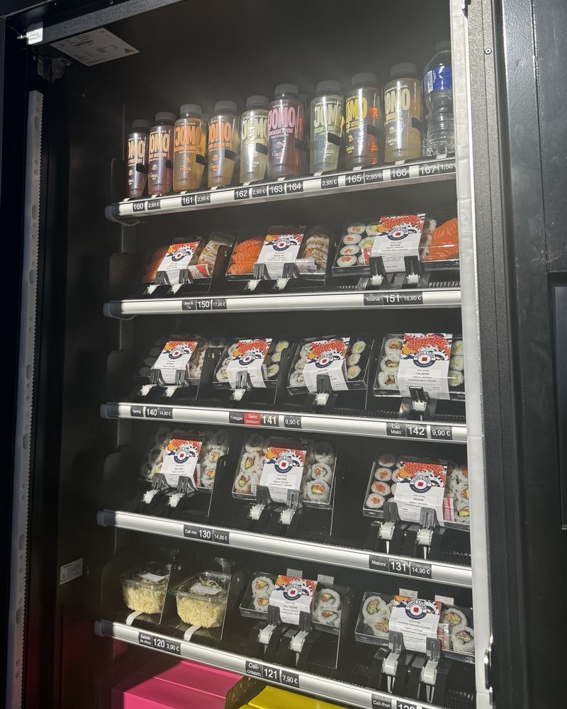 L'intérieur d'un distributeur Sushi Store rempli de boîtes de sushis et de boissons